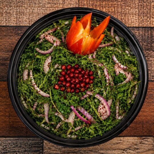 Arugula salad with red onion, pomegranate and sumac